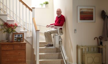 Eldre mann som bruker trappeheisen