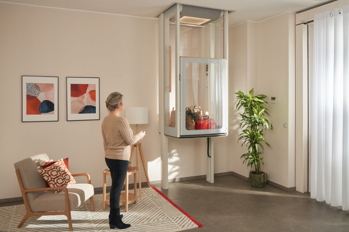 Kvinne i stuen sin som løfter dagvarene ved hjelp av Uplifts S2.