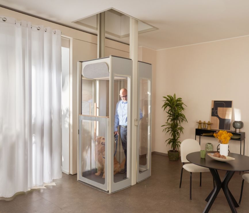 En middelaldrende mann med hunden sin i en Uplifts S3 installert i en moderne stue.