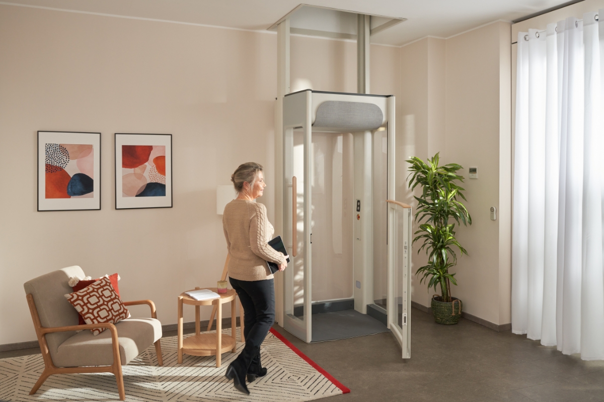 Middelaldrende kvinne smiler mens hun går til en Uplifts S2-boligheis.