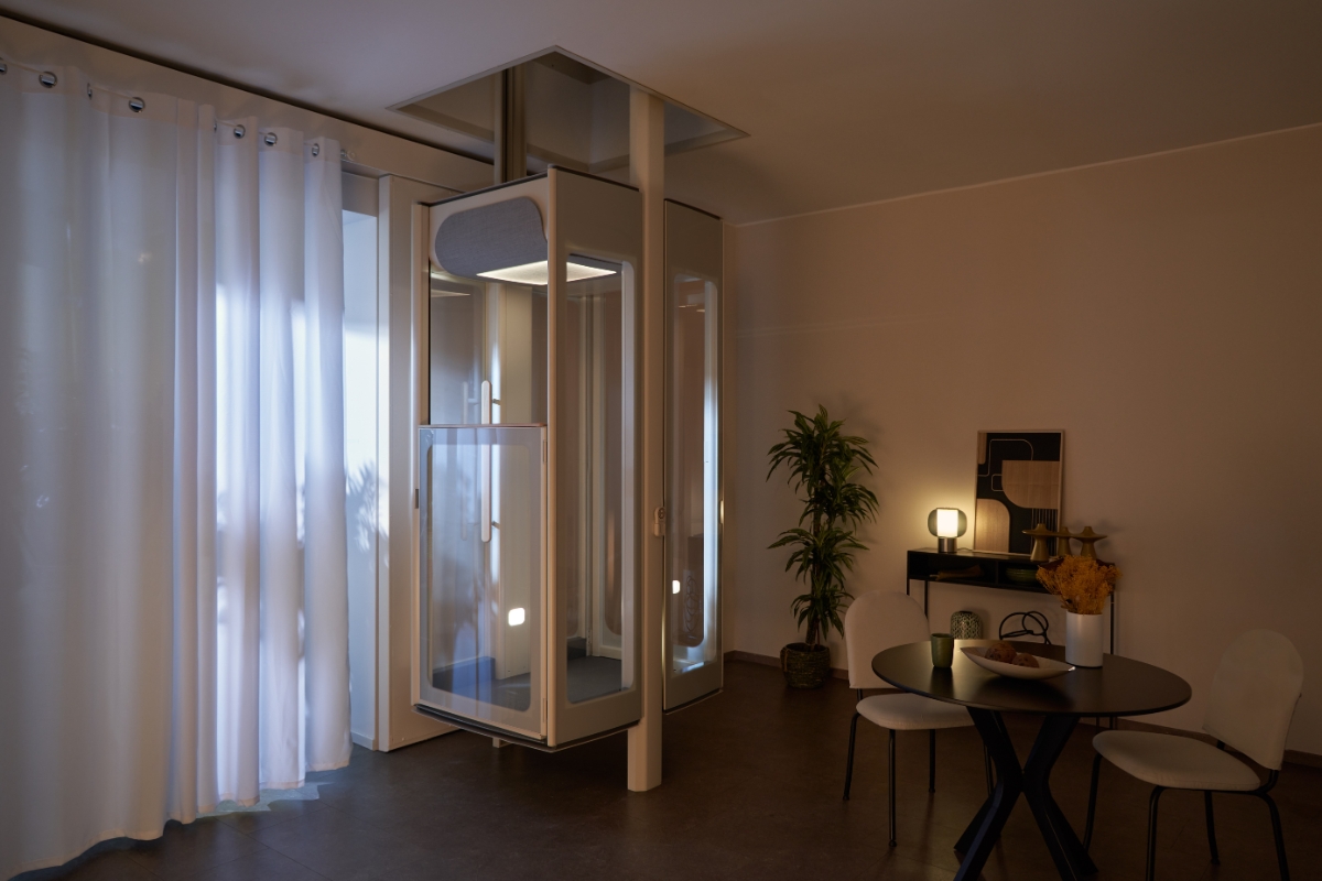  Stannah Uplifts-boligheis om kvelden med innvendig belysning, parkert mellom etasjer i et moderne oppholdsrom.